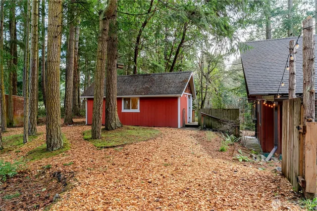 a view of a large house with large trees and covered with wooden fence