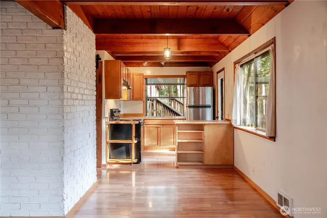a view of an empty room with a fireplace and a window