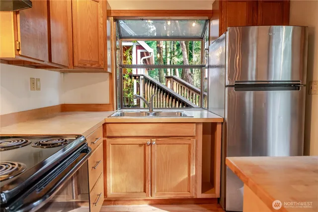 a kitchen with stainless steel appliances granite countertop a refrigerator and a stove