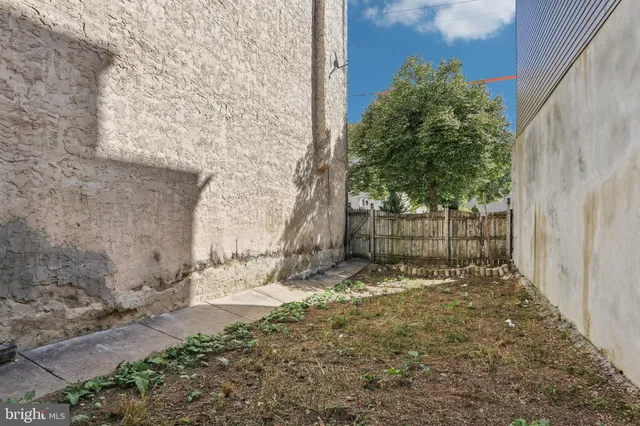 a view of a yard with wooden fence