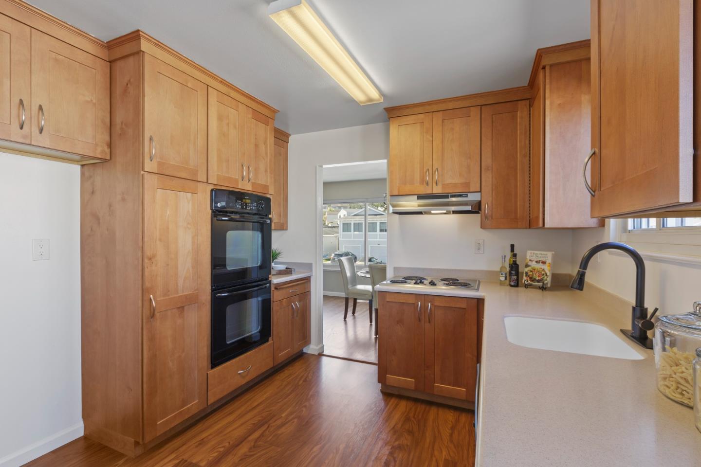 4366 Callan Boulevard Daly City, CA 94015 - Photo 13 of 38 a kitchen with granite countertop wooden floors stainless steel appliances and sink