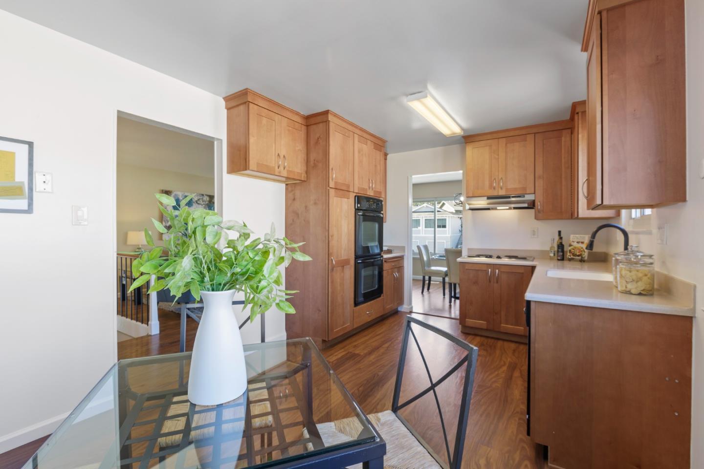 4366 Callan Boulevard Daly City, CA 94015 - Photo 18 of 38 a kitchen with stainless steel appliances kitchen island granite countertop a refrigerator a stove a sink a dining table and chairs with wooden floor