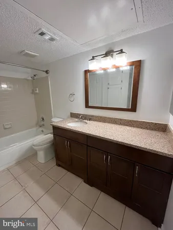 a bathroom with a sink mirror and a toilet