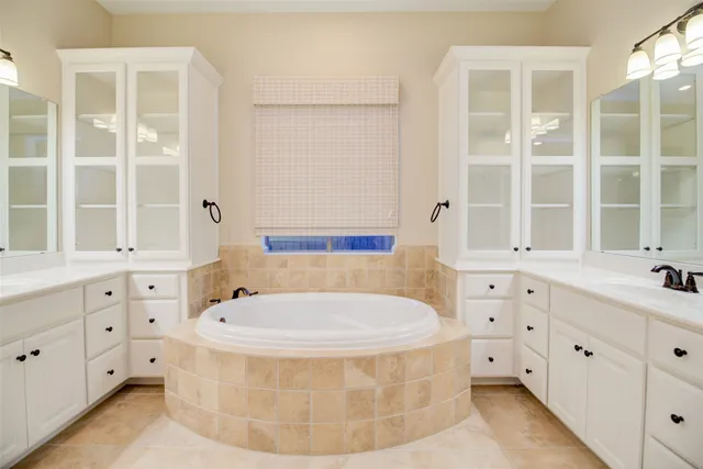 a bathroom with a tub sink and mirror