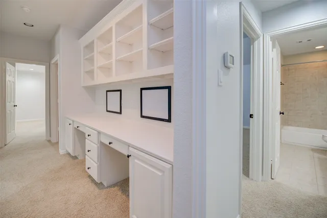 an empty room with a chandelier fan and windows
