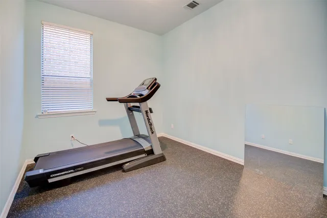 a room with gym equipment and windows