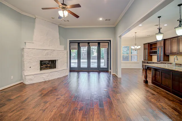 an empty room with wooden floor fireplace and windows
