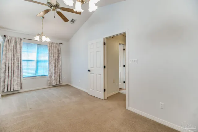 wooden floor in an empty room with a chandelier fan