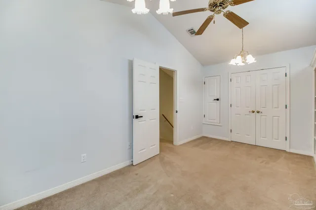an empty room with a window and a ceiling fan
