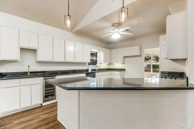 a kitchen with kitchen island a white cabinets and refrigerator