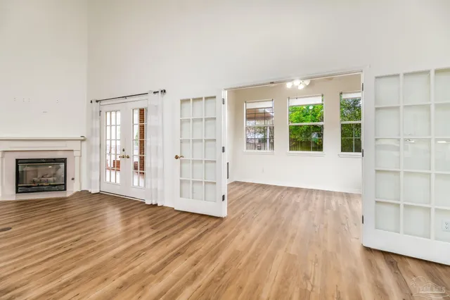 an empty room with wooden floor and fireplace