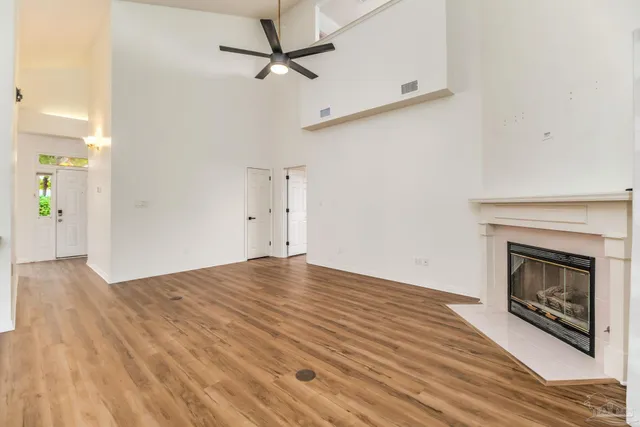 a view of empty room with wooden floor and fireplace