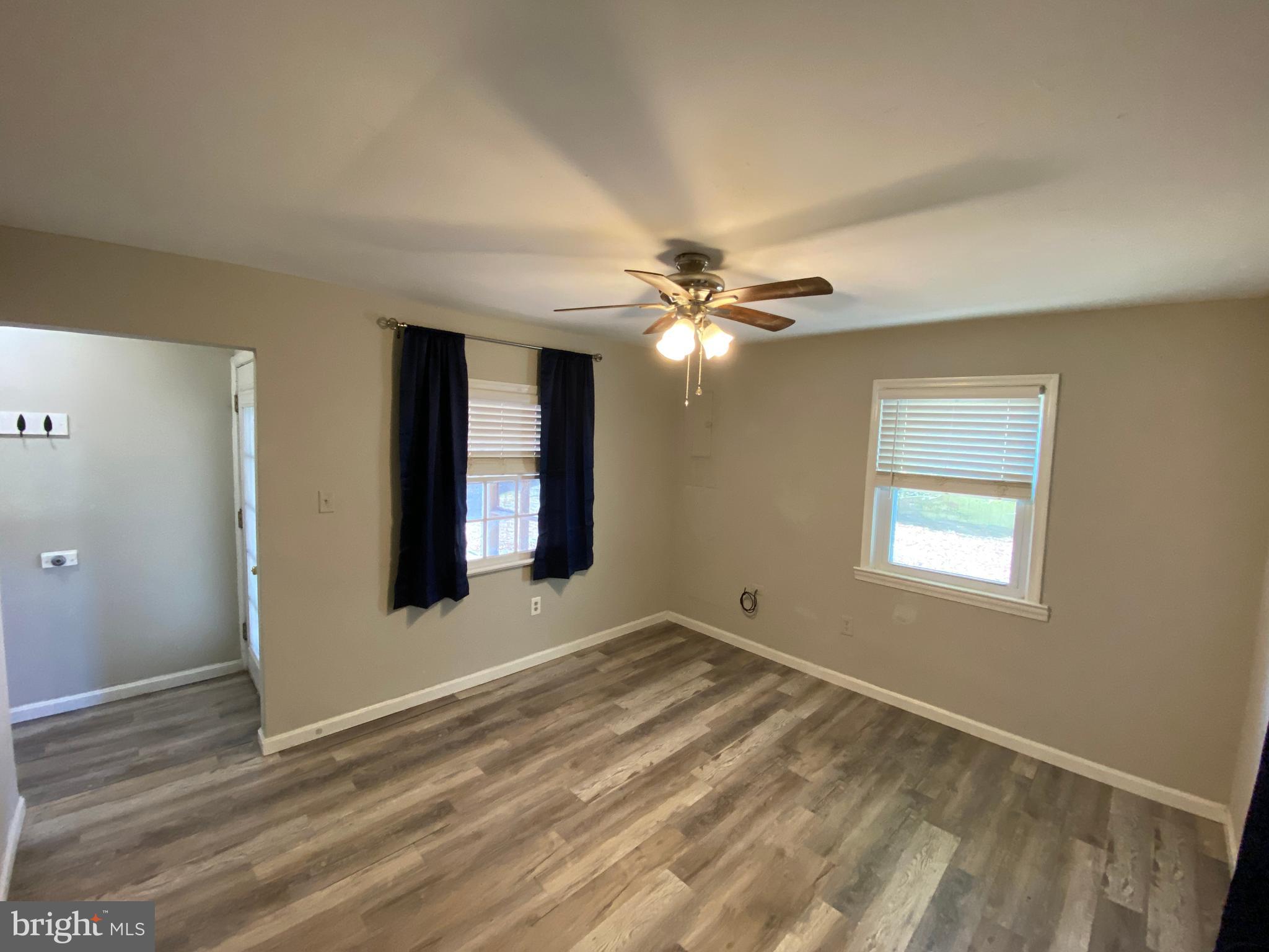 205 North Irving Avenue Colonial Beach, VA 22443 - Photo 8 of 22 a view of an empty room with window and chandelier fan