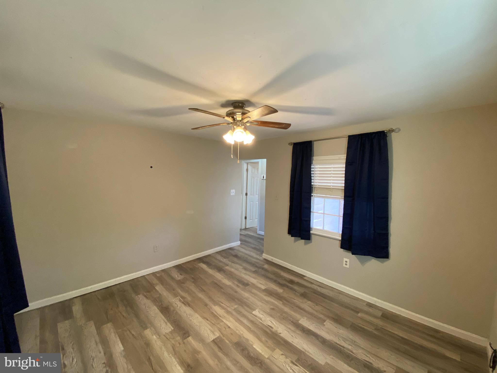 205 North Irving Avenue Colonial Beach, VA 22443 - Photo 9 of 22 a view of an empty room with window and chandelier fan