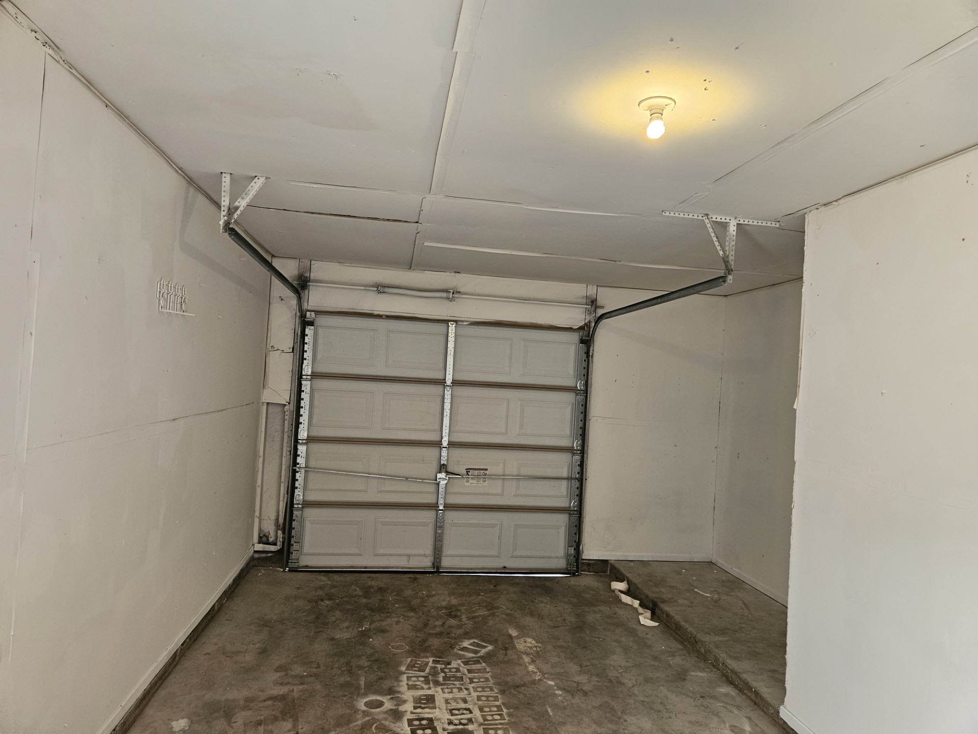 805 Lexington Road, Unit B Elgin, TX 78621 - Photo 10 of 11 Functional garage space with a secure overhead door and practical lighting.