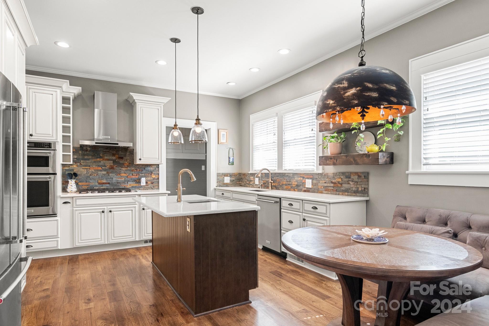 221 Ridgeway Avenue Statesville, NC 28677 - Photo 12 of 45 a kitchen with kitchen island granite countertop a sink stove and white cabinets with wooden floor
