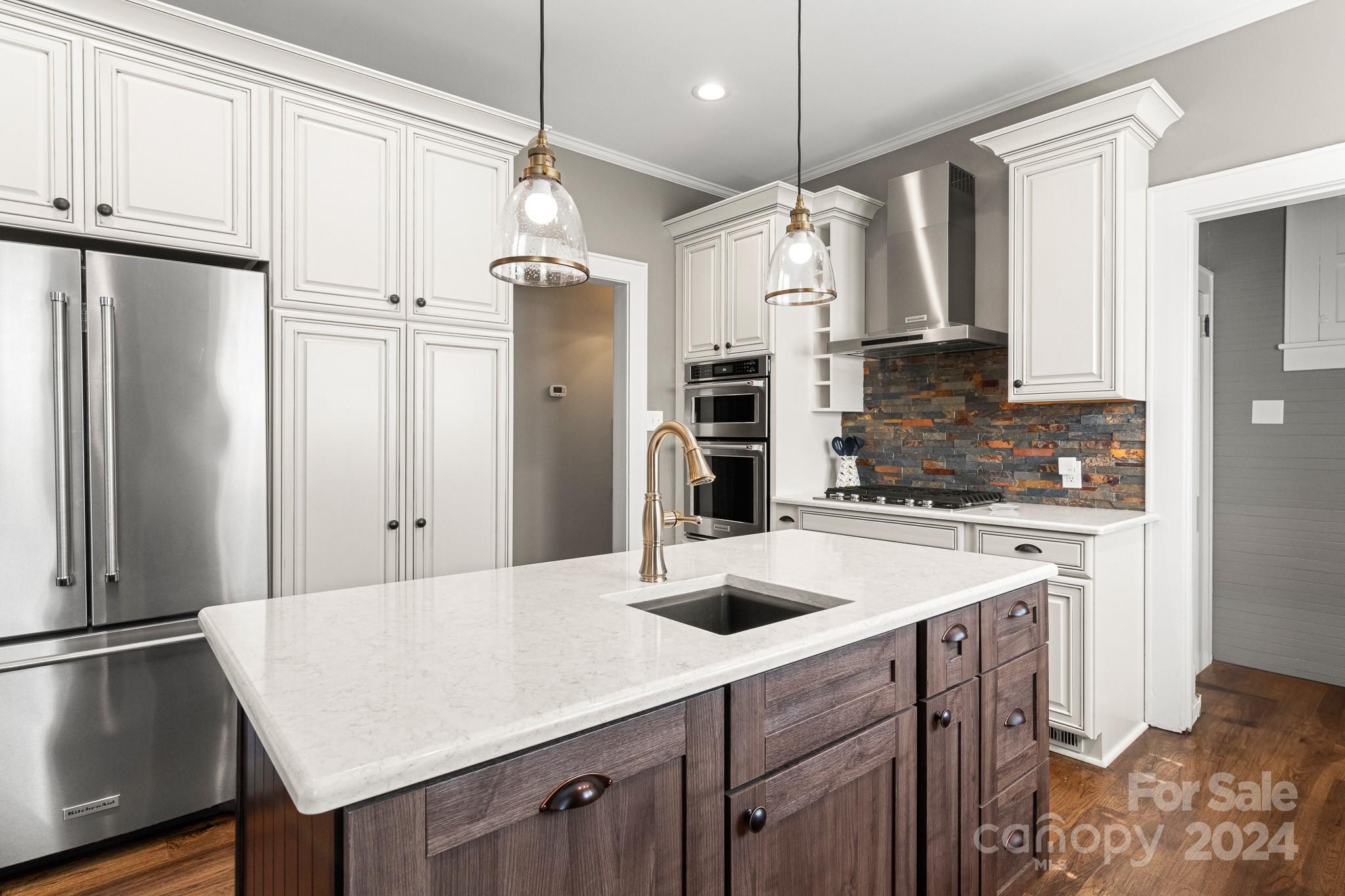 221 Ridgeway Avenue Statesville, NC 28677 - Photo 16 of 45 a kitchen with stainless steel appliances a sink a refrigerator a center island and cabinets