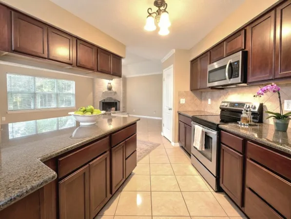 a large kitchen with stainless steel appliances granite countertop a sink and a counter space