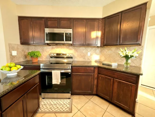 a kitchen with granite countertop stainless steel appliances and wooden cabinets