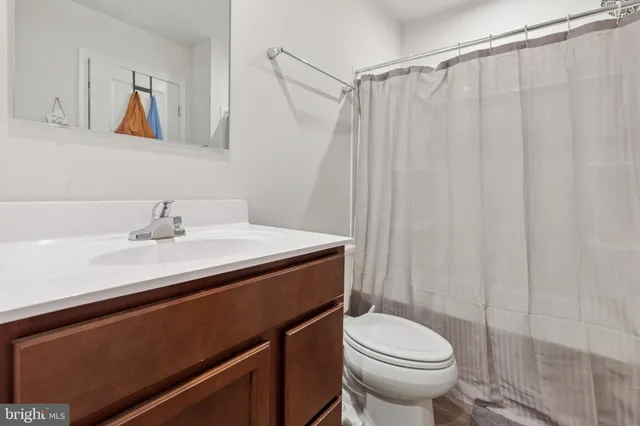 a bathroom with a sink a toilet and shower curtain