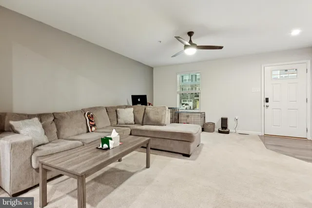 a living room with furniture and a ceiling fan