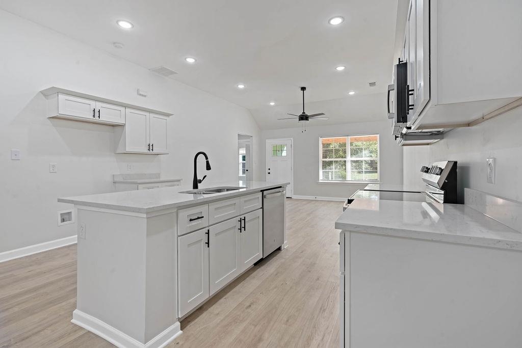 372 Edith Avenue Memphis, TN 38126 - Photo 19 of 23 Kitchen featuring lofted ceiling, white cabinets, light stone countertops, recessed lighting, and stainless steel appliances