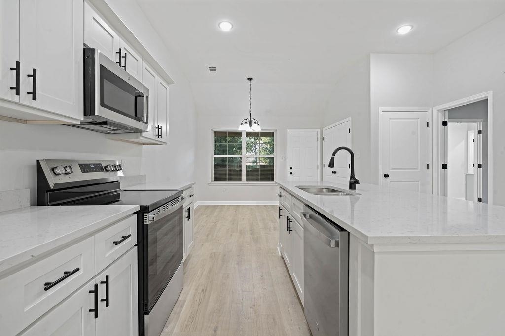 372 Edith Avenue Memphis, TN 38126 - Photo 21 of 23 Kitchen featuring stainless steel appliances, white cabinetry, light stone countertops, light wood-style flooring, and recessed lighting