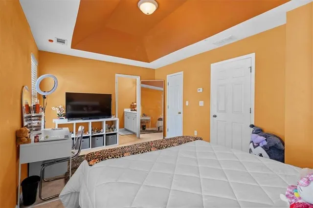 a bedroom with a bed and a dresser next to a window