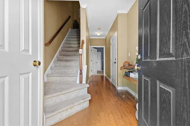 a view of a hallway with wooden floor and staircase