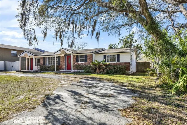 a front view of house with yard and trees in the background