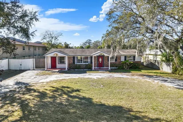 a view of a white house with a large pool and large trees