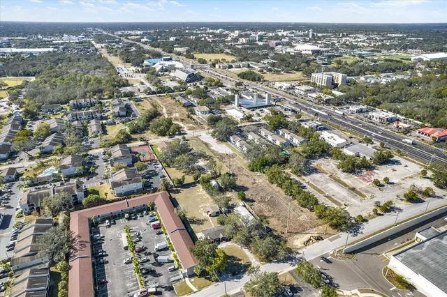 an aerial view of residential building with parking and yard