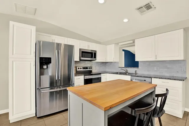 a kitchen with a refrigerator a stove a microwave and island with wooden floor