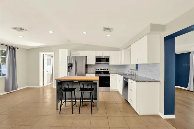 a large kitchen with a table and chairs