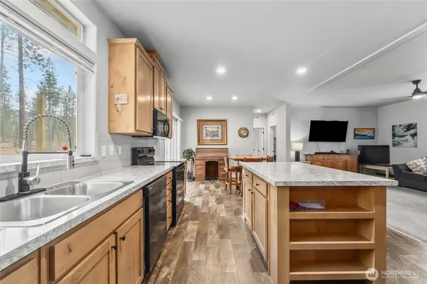 a view of a kitchen with kitchen island a sink appliances and a counter top space