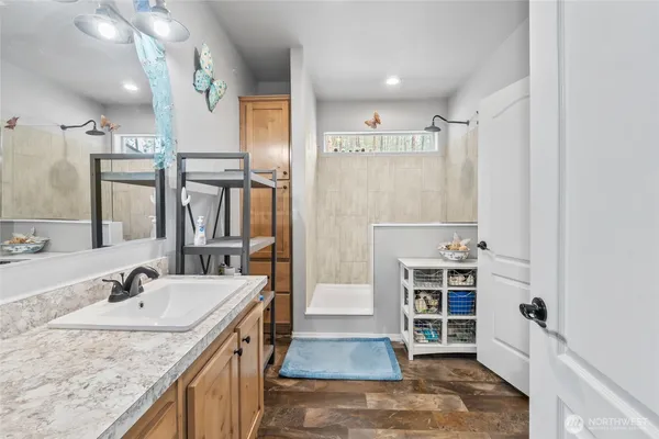 a bathroom with a granite countertop sink and a washing machine