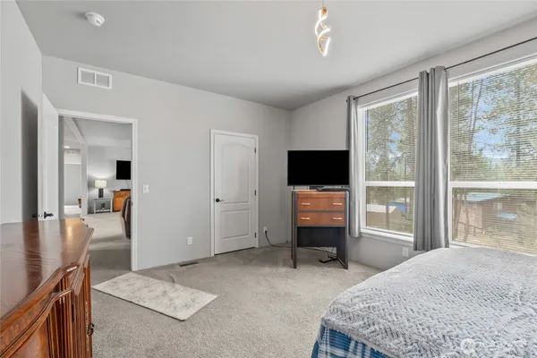 a bedroom with furniture and large windows