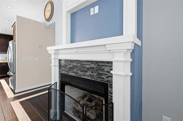 a kitchen with stainless steel appliances a dining table chairs and fireplace