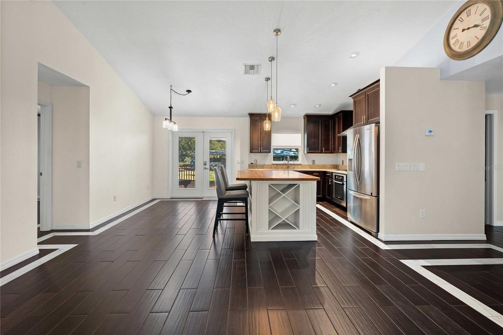 7037 County Road 625 Bushnell, FL 33513 - Photo 16 of 72 a kitchen with stainless steel appliances a dining table chairs refrigerator and sink