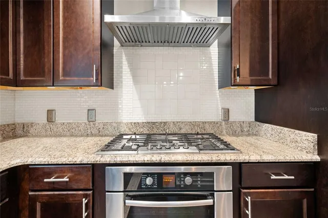 an empty room with wooden floor closet and windows
