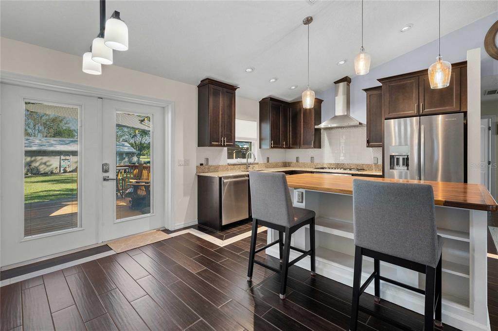 7037 County Road 625 Bushnell, FL 33513 - Photo 22 of 72 a kitchen with stainless steel appliances a dining table chairs and fireplace