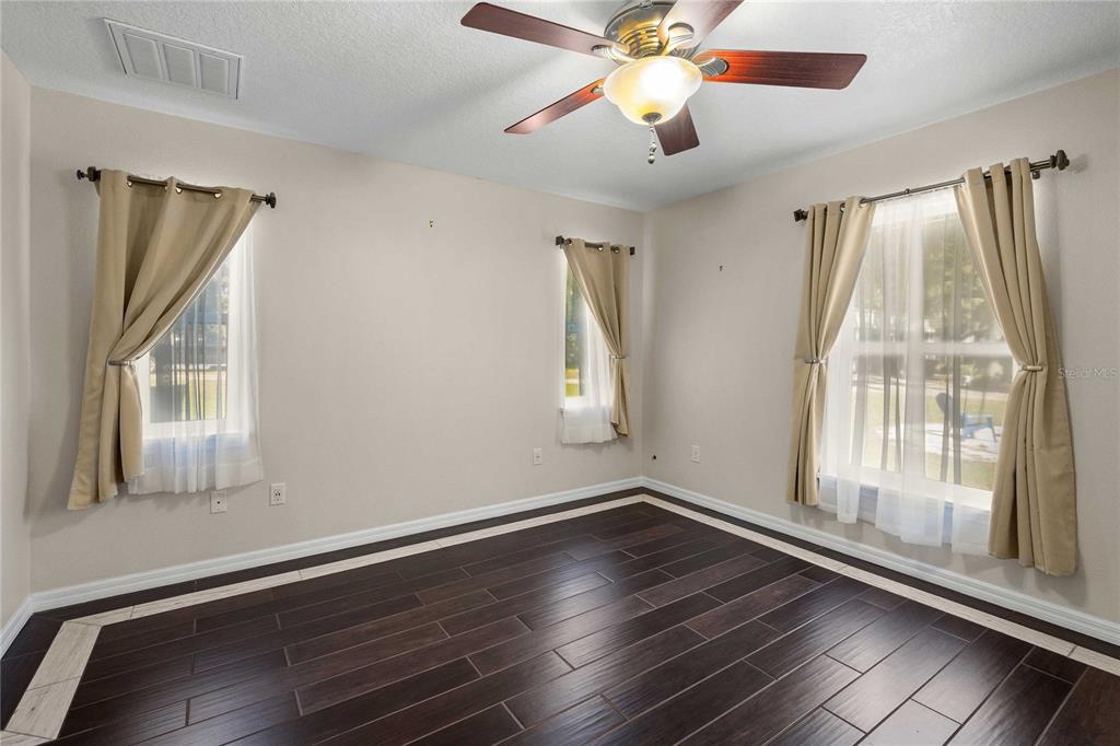 7037 County Road 625 Bushnell, FL 33513 - Photo 31 of 72 a view of an empty room with wooden floor and a window