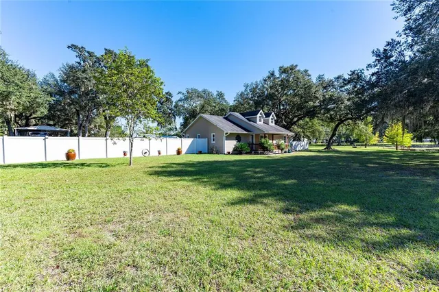 a view of a house with backyard and sitting area