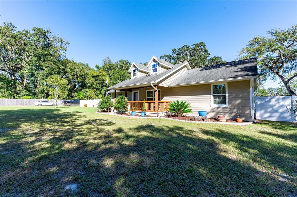 7037 County Road 625 Bushnell, FL 33513 - Photo 39 of 72 a front view of a house with a garden and porch