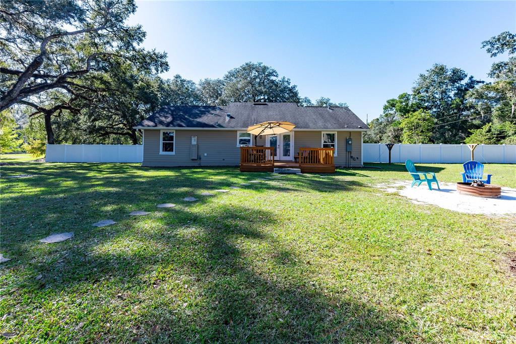 7037 County Road 625 Bushnell, FL 33513 - Photo 52 of 72 a view of a house with a big yard potted plants and large tree