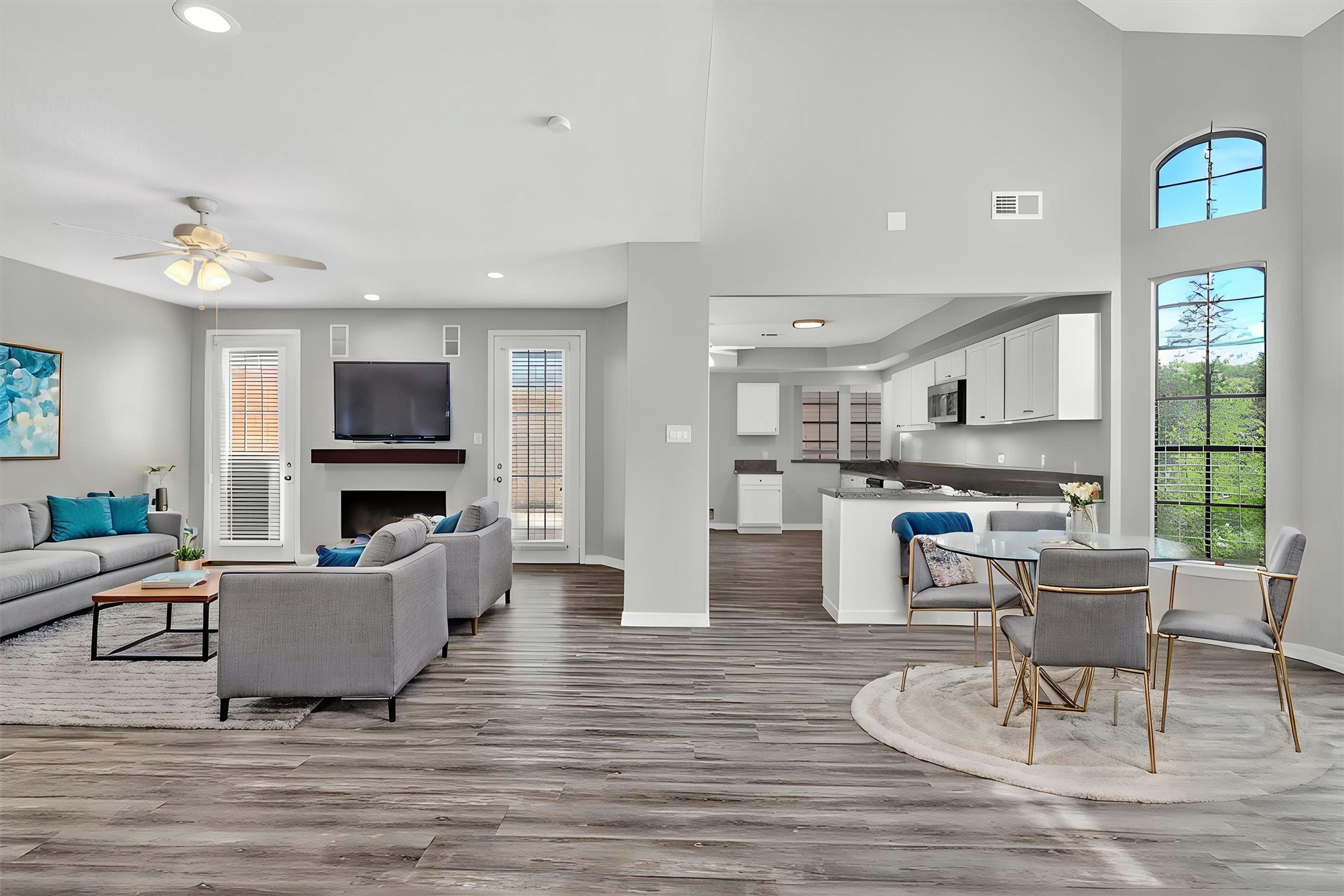 12929 Kingsbridge Lane Houston, TX 77077 - Photo 6 of 42 Virtually Staged — Experience the beauty of this light-filled open-concept living space featuring soaring ceilings, expansive windows, and a modern designer feel throughout. This stunning layout offers seamless flow between the living, dining, and kitchen areas, making it perfect for entertaining and everyday living. Buyers will love the updated flooring, contemporary finishes, sleek fireplace, and spacious gourmet kitchen with abundant cabinetry and counter space.