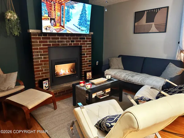 a living room with furniture a fireplace and a flat screen tv