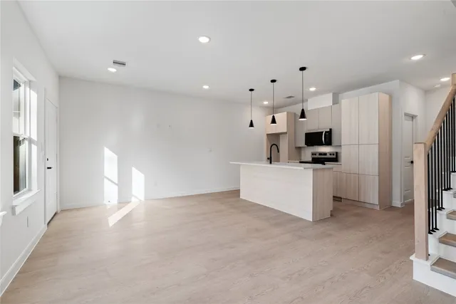 a view of a kitchen with refrigerator and white cabinets