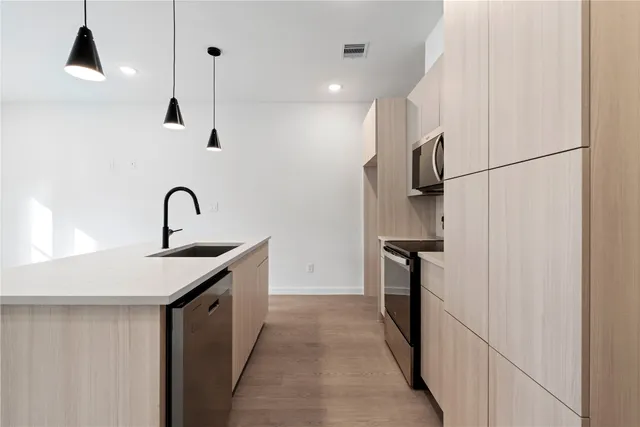 a kitchen with stainless steel appliances a sink and a refrigerator