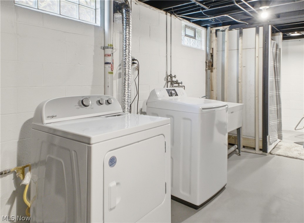2411 Ridgeview Lane Youngstown, OH 44514 - Photo 27 of 48 Dedicated laundry area featuring a white washing machine, white dryer, utility sink with faucet, white painted block walls, and concrete flooring